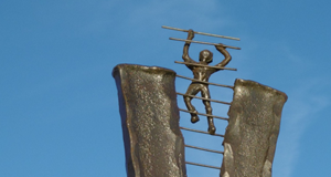 image of sculpture with human figure climbing ladder into sky